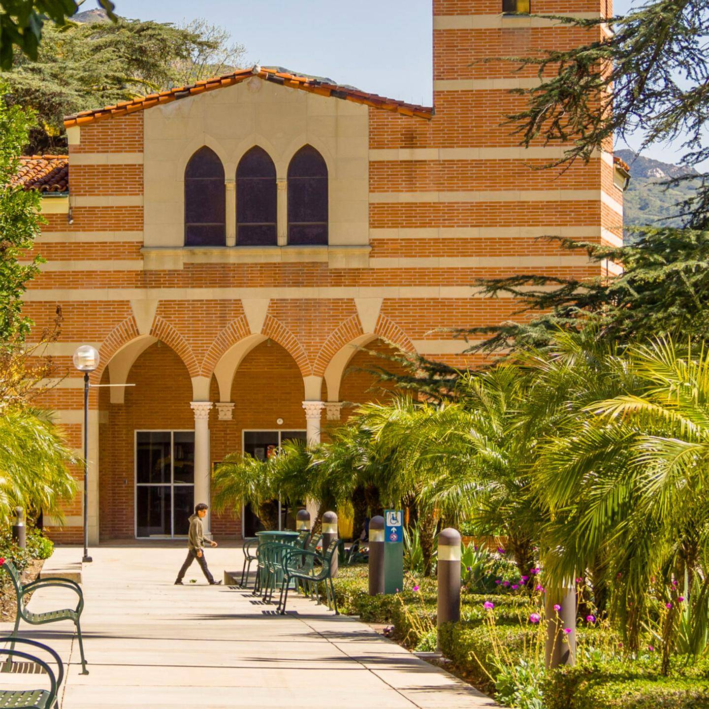 Far sight shot of a building in the Woodbury library, with a student walking by.
