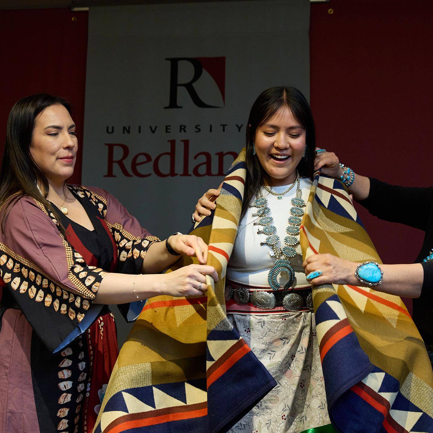 Mutiple media - Native student programs student at ceremony