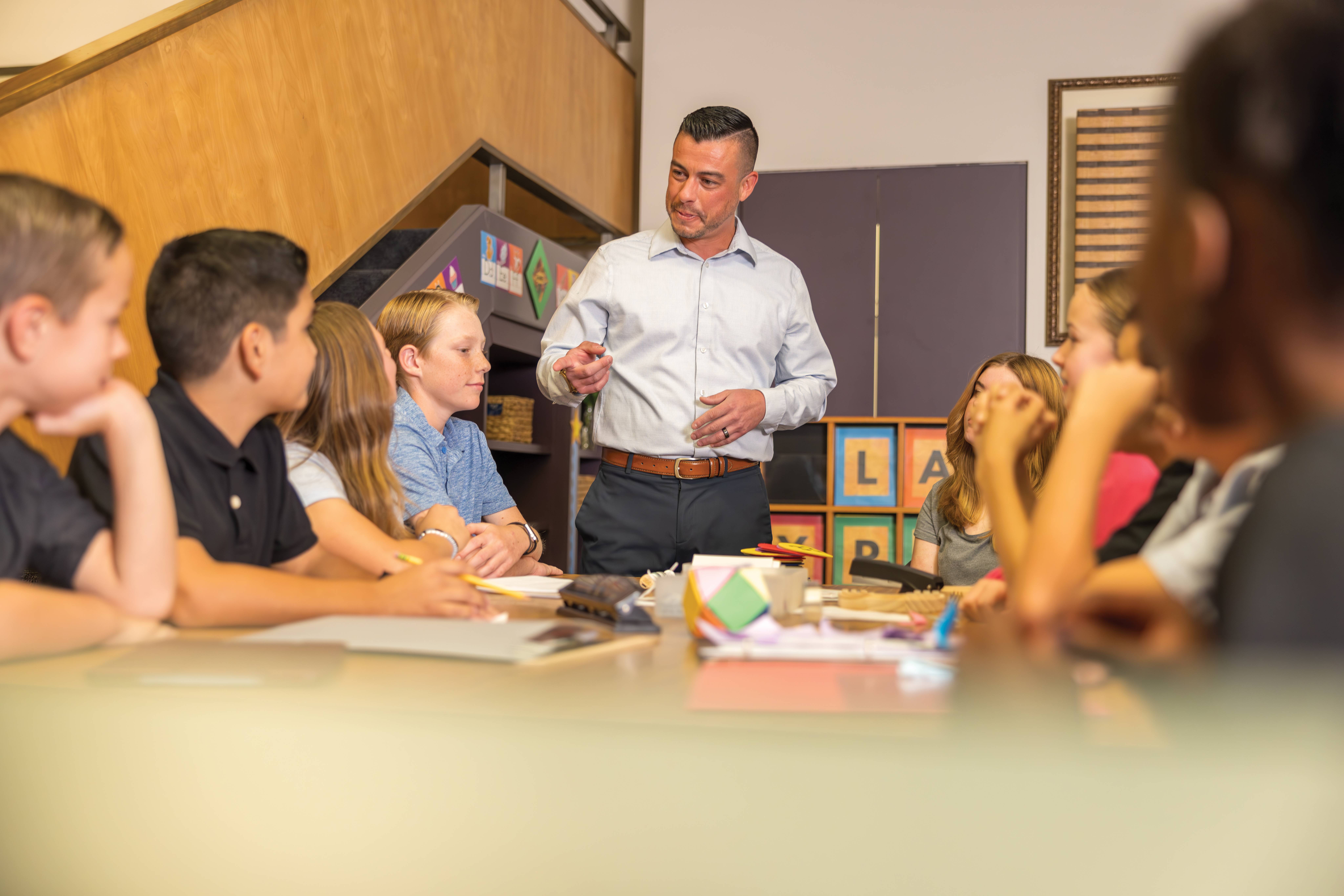 students interacting with instructor at conference table