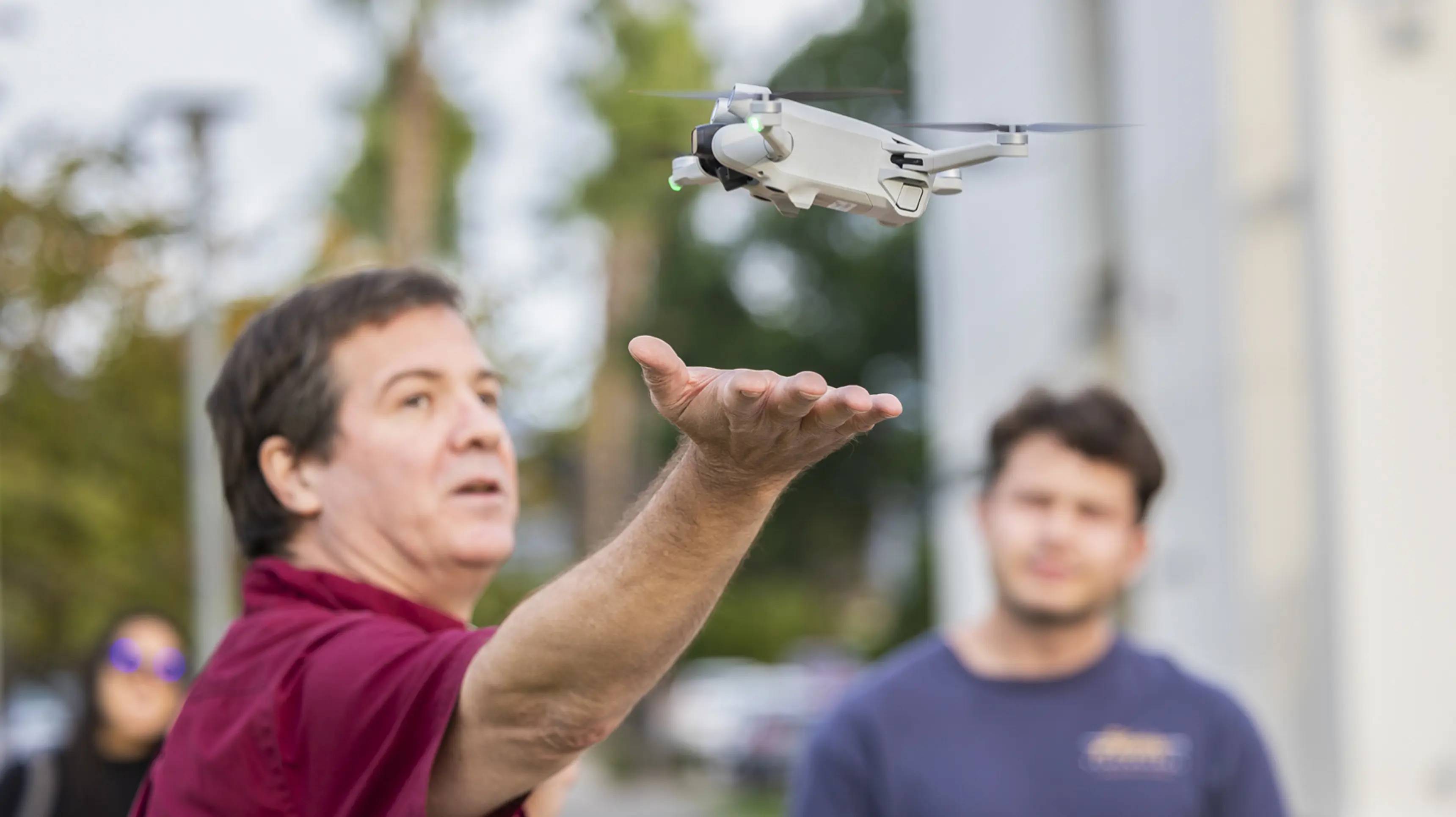 Instructor with drone flying out of his hand.