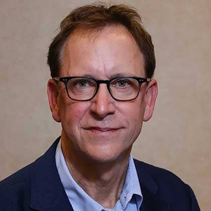 Rob Harris sitting and smiling for photo.