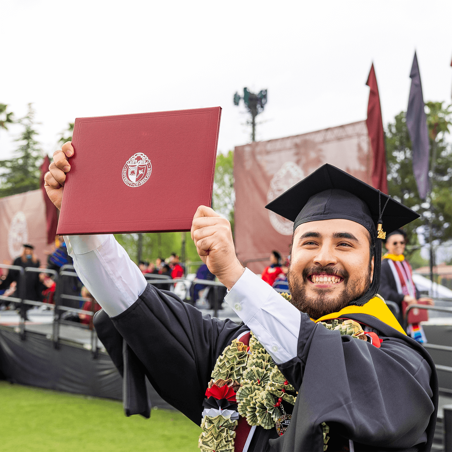 Mutiple media card - Graduate proudly holding up diploma