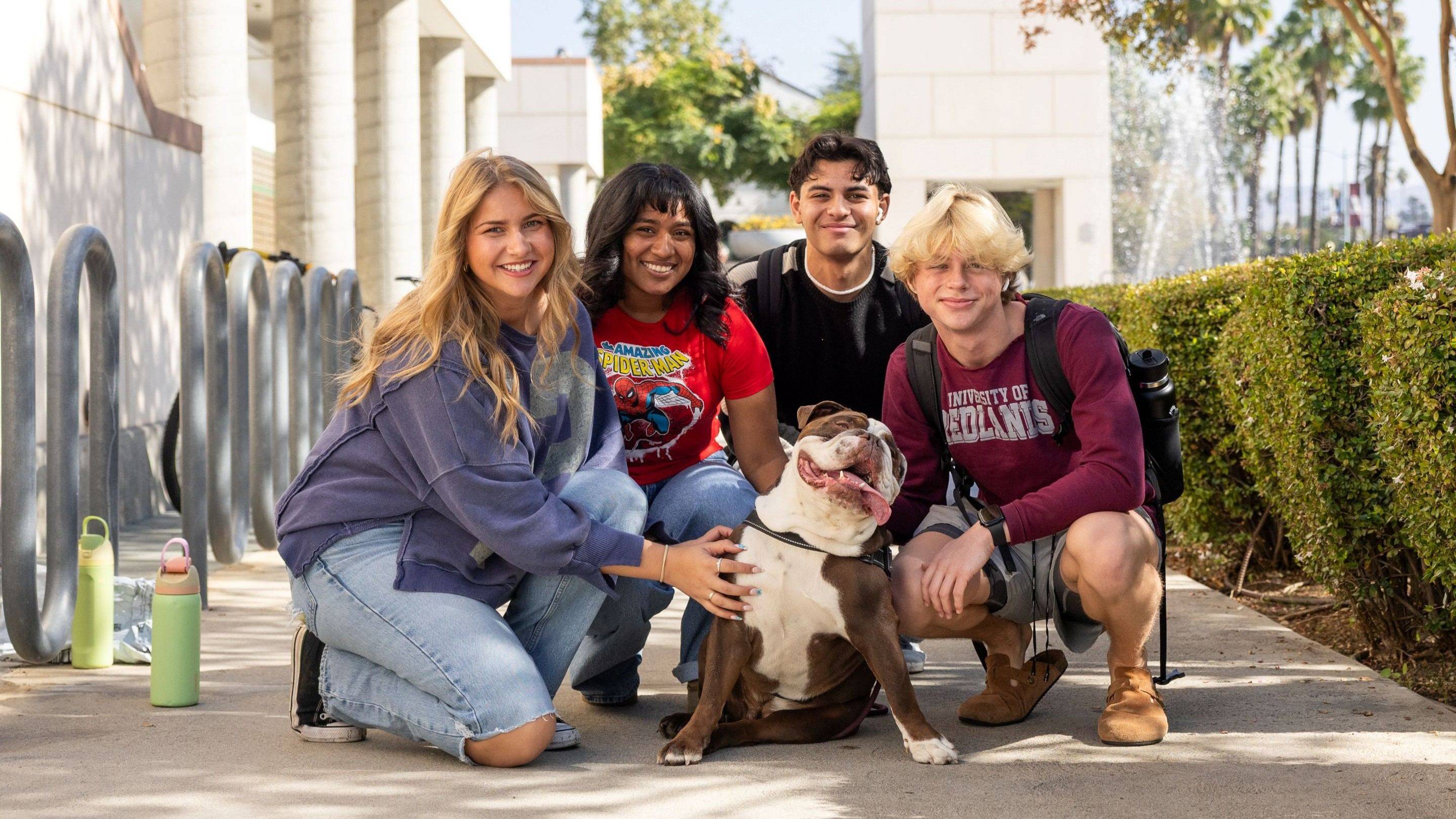 a group of people posing with a dog
