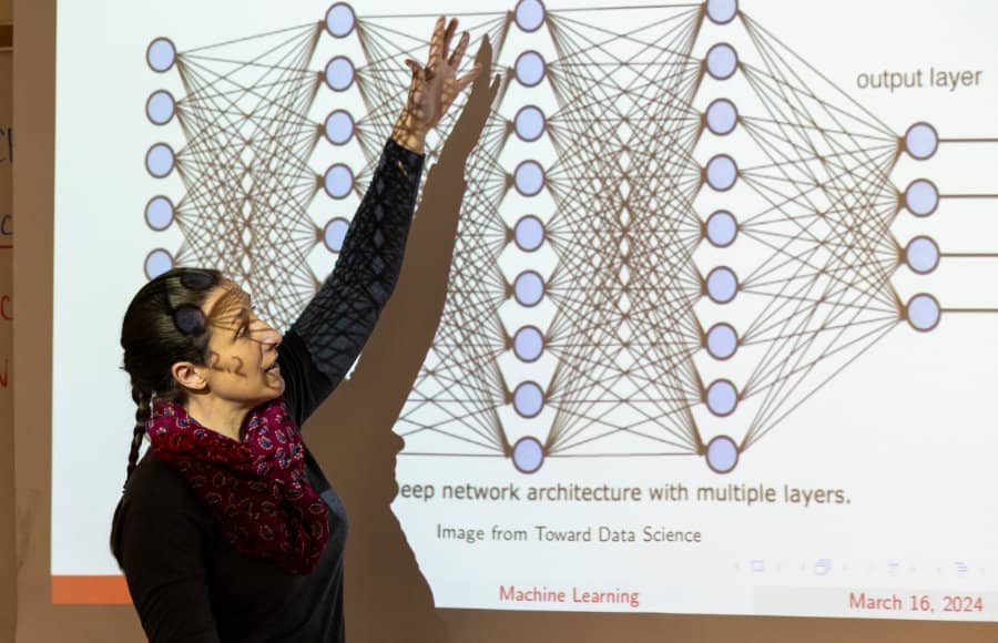 a woman standing in front of a projection screen