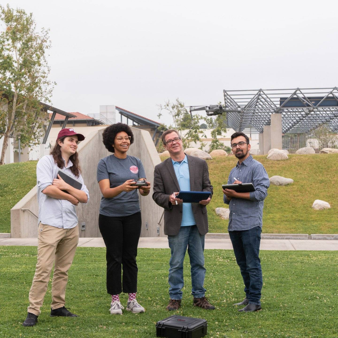 Students and instructor flying a drone near Lewis Hall.