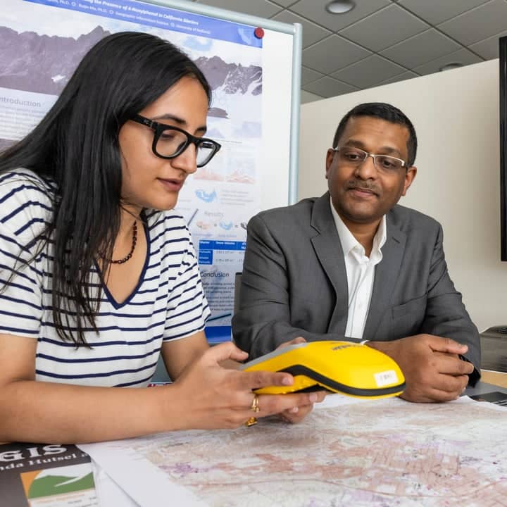 Instructor and student talking with map visual displaying on a TV screen.