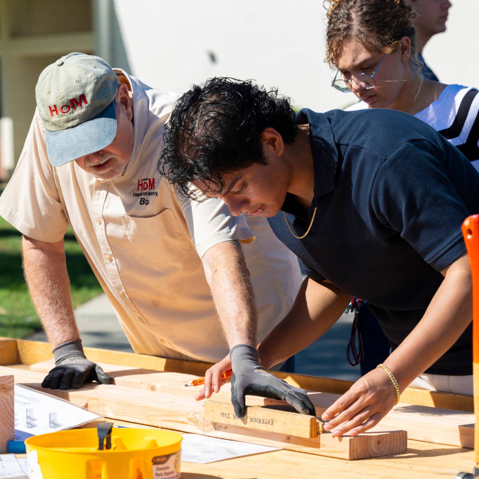 a group of people working on a wood plank