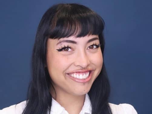 a woman with piercings and nose ring smiling