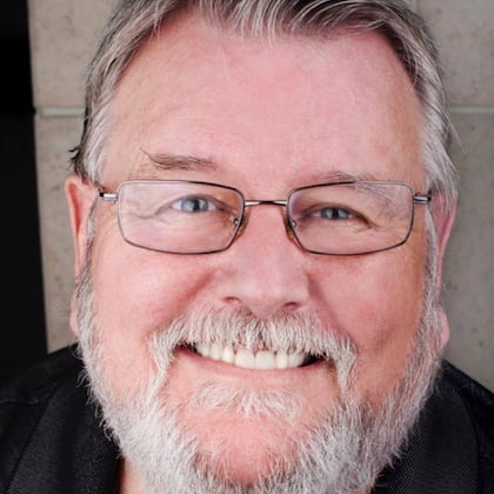 a man with glasses smiling