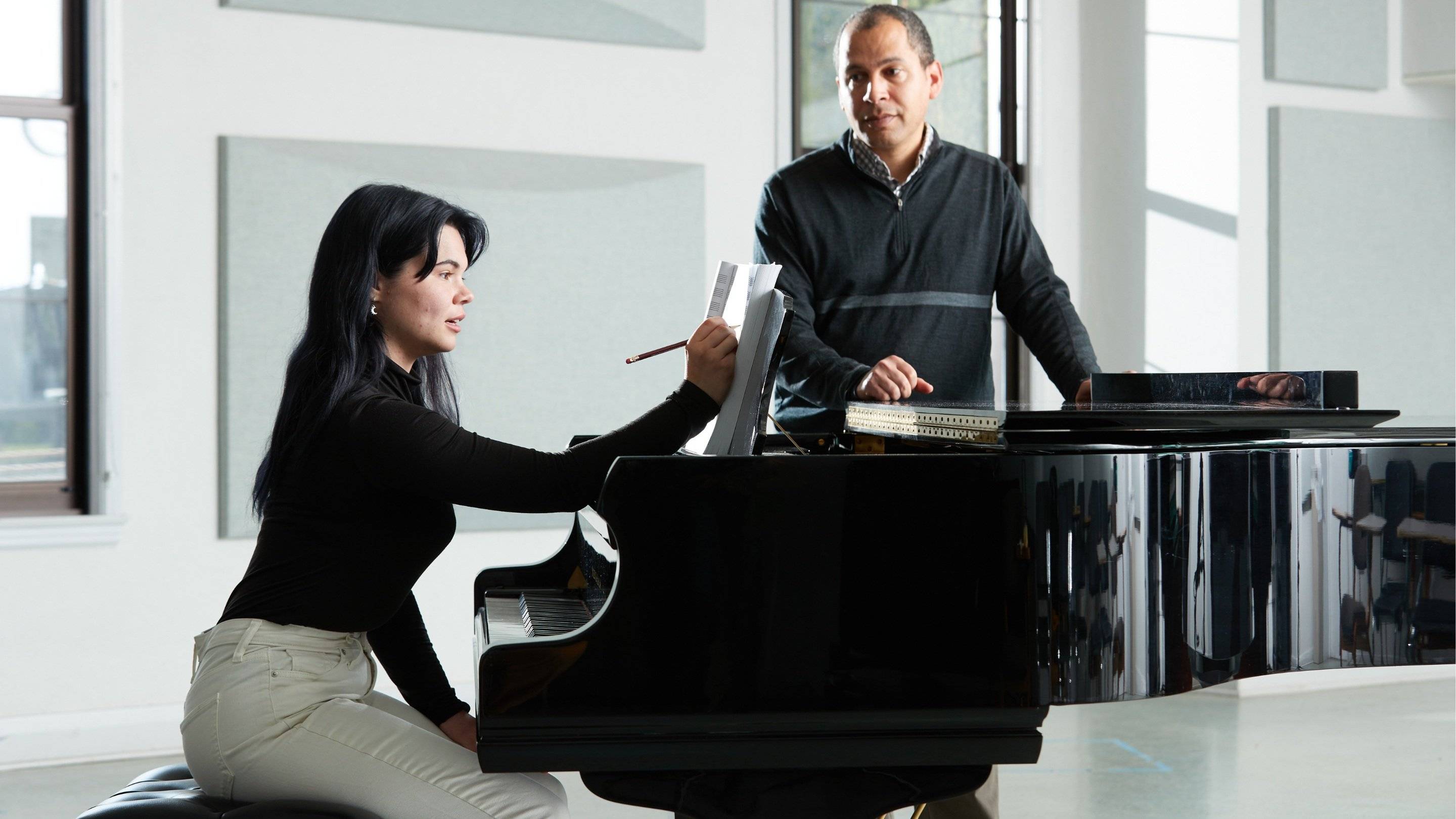 a man and woman sitting at a piano