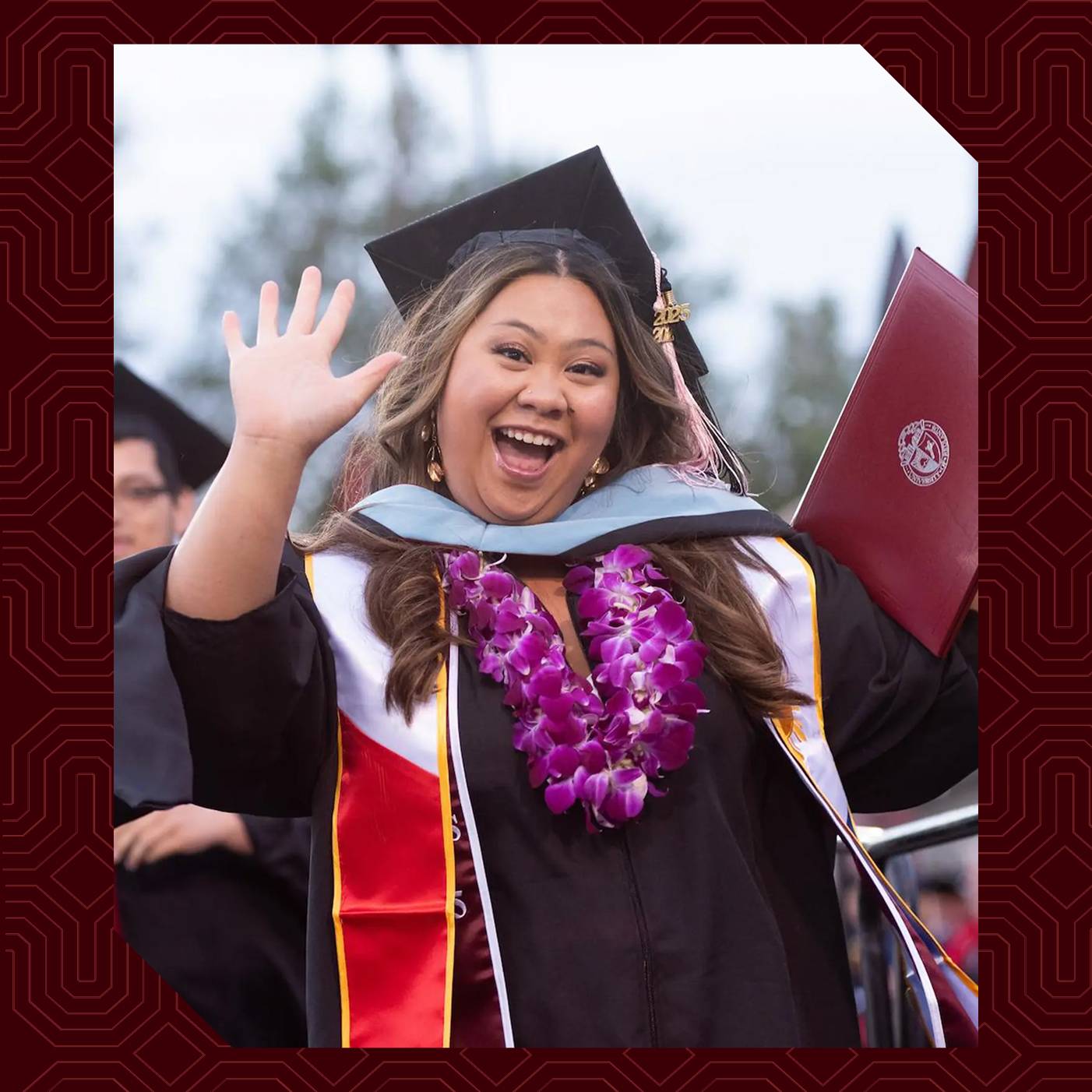 a woman in a graduation gown waving
