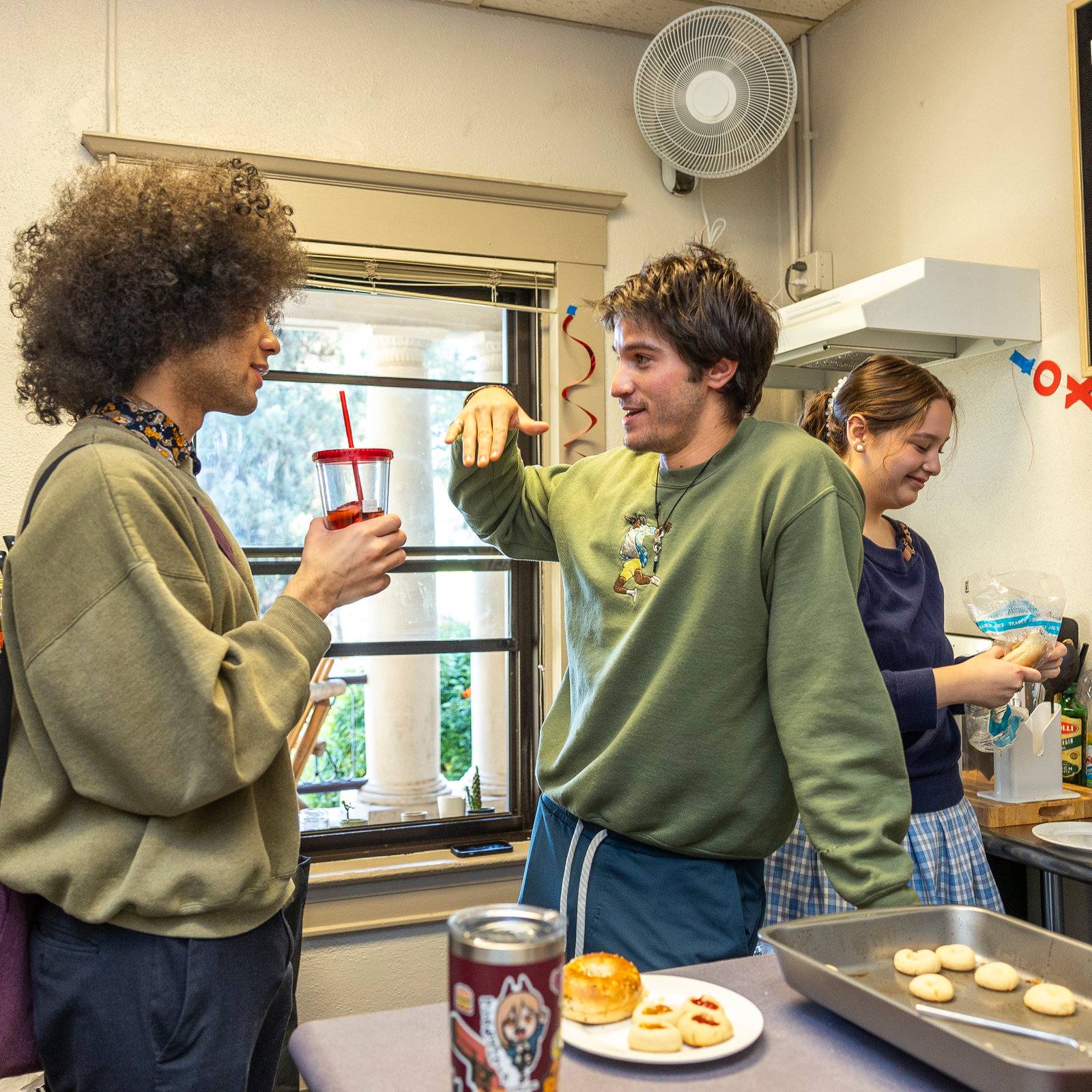 a group of people standing in a kitchen