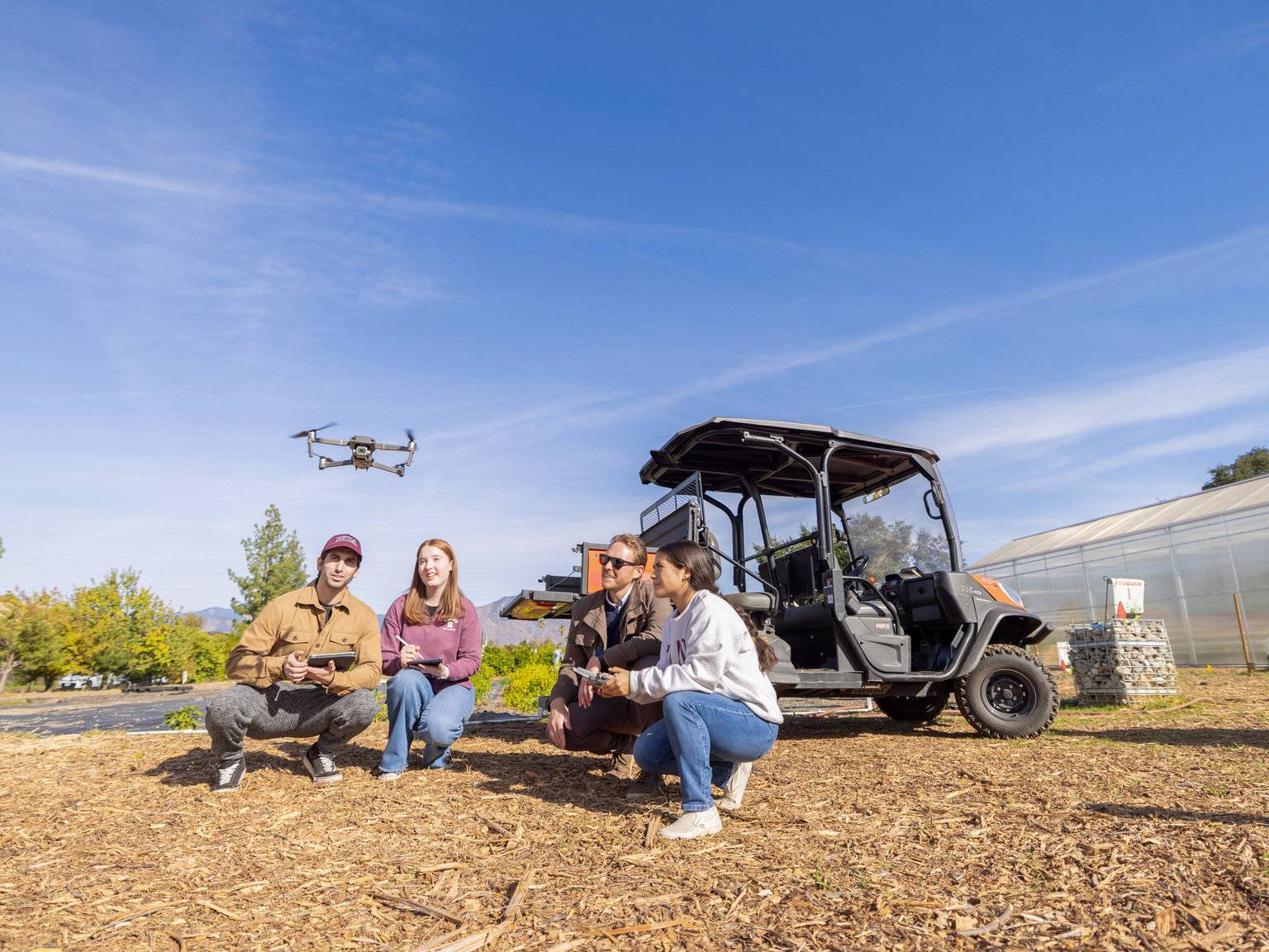 a group of people sitting next to a small vehicle