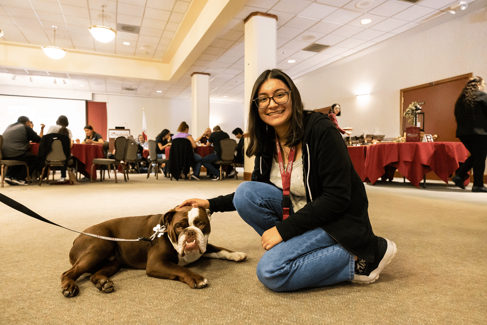 a woman sitting on the floor with a dog