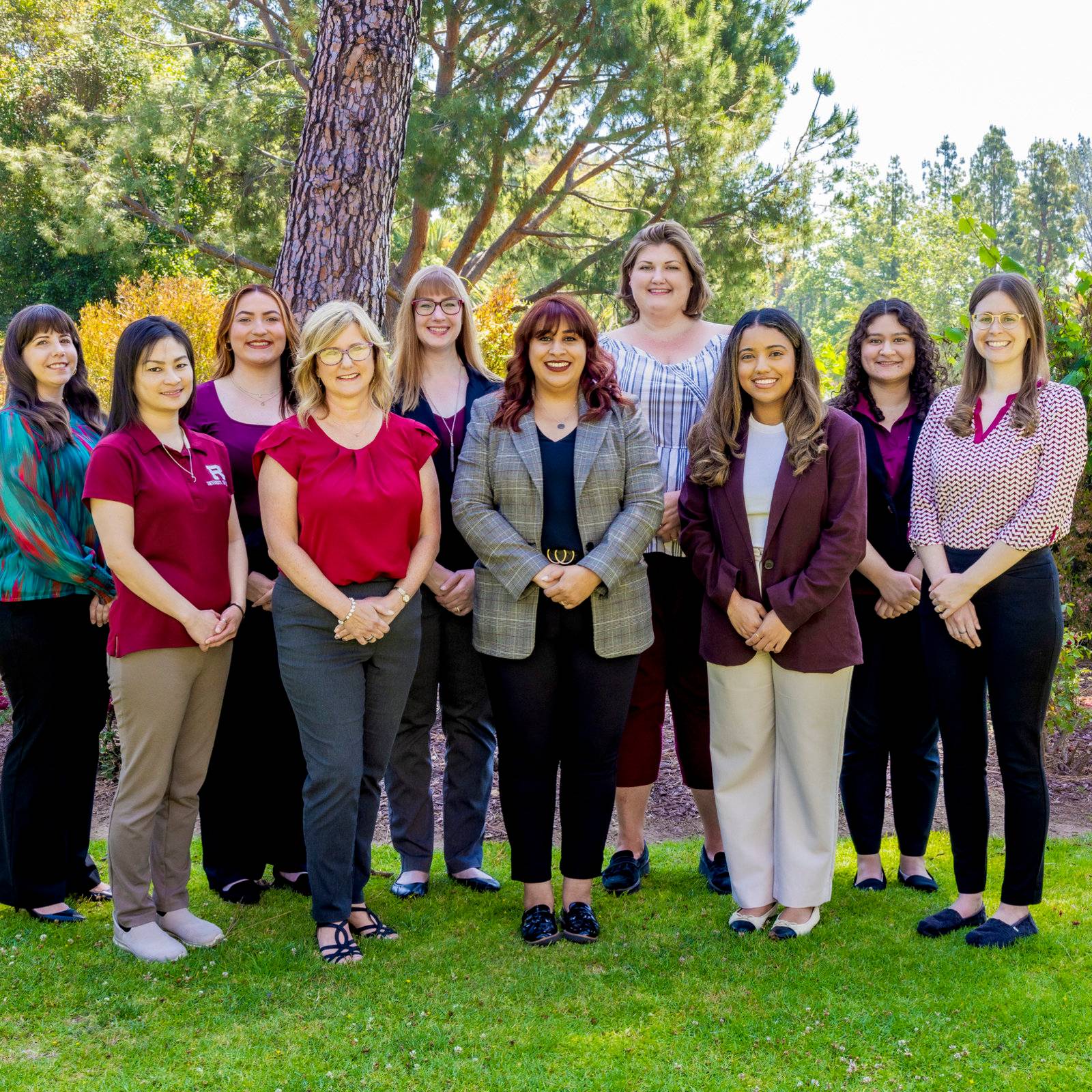 a group of women standing together in a grassy area
