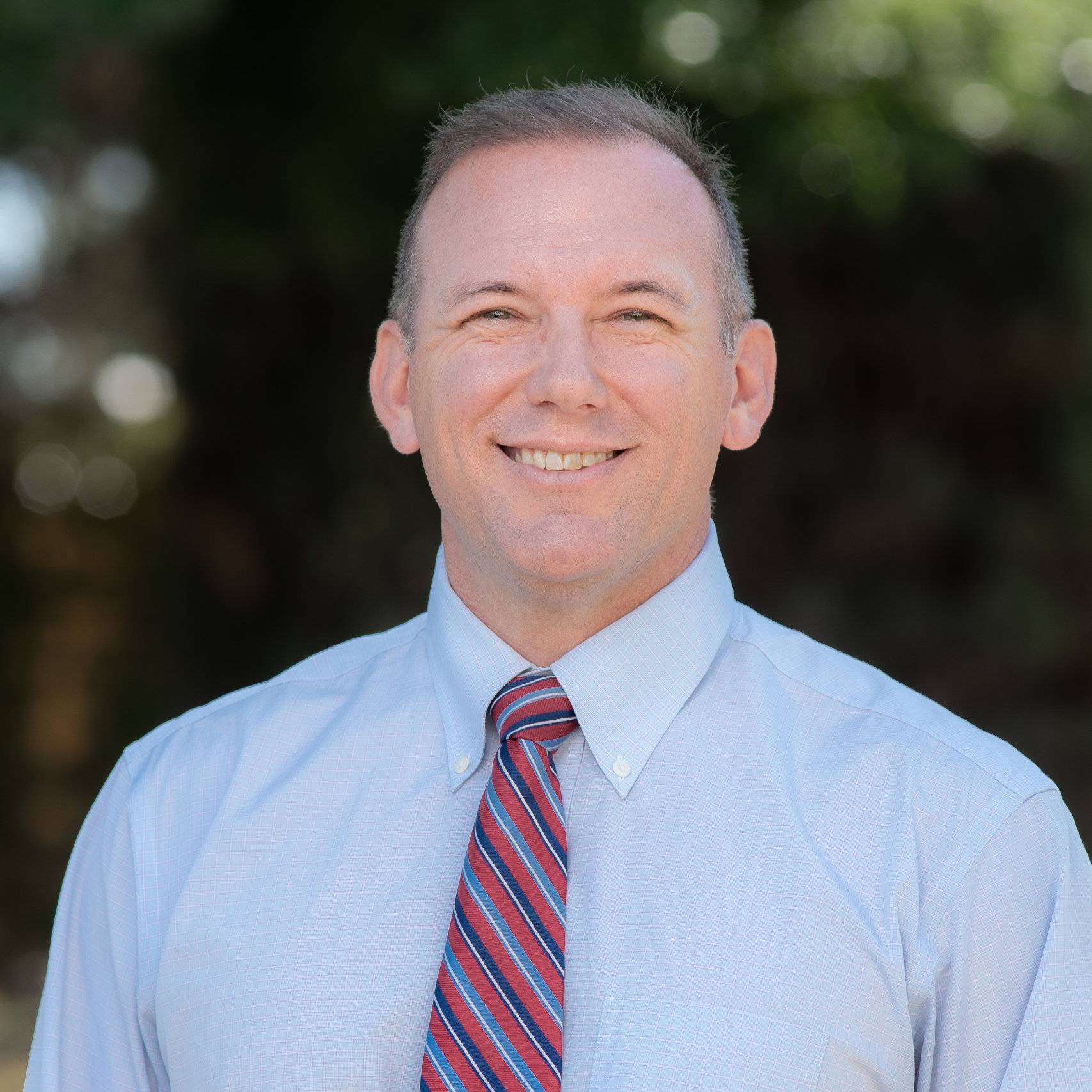 a man wearing a tie and smiling