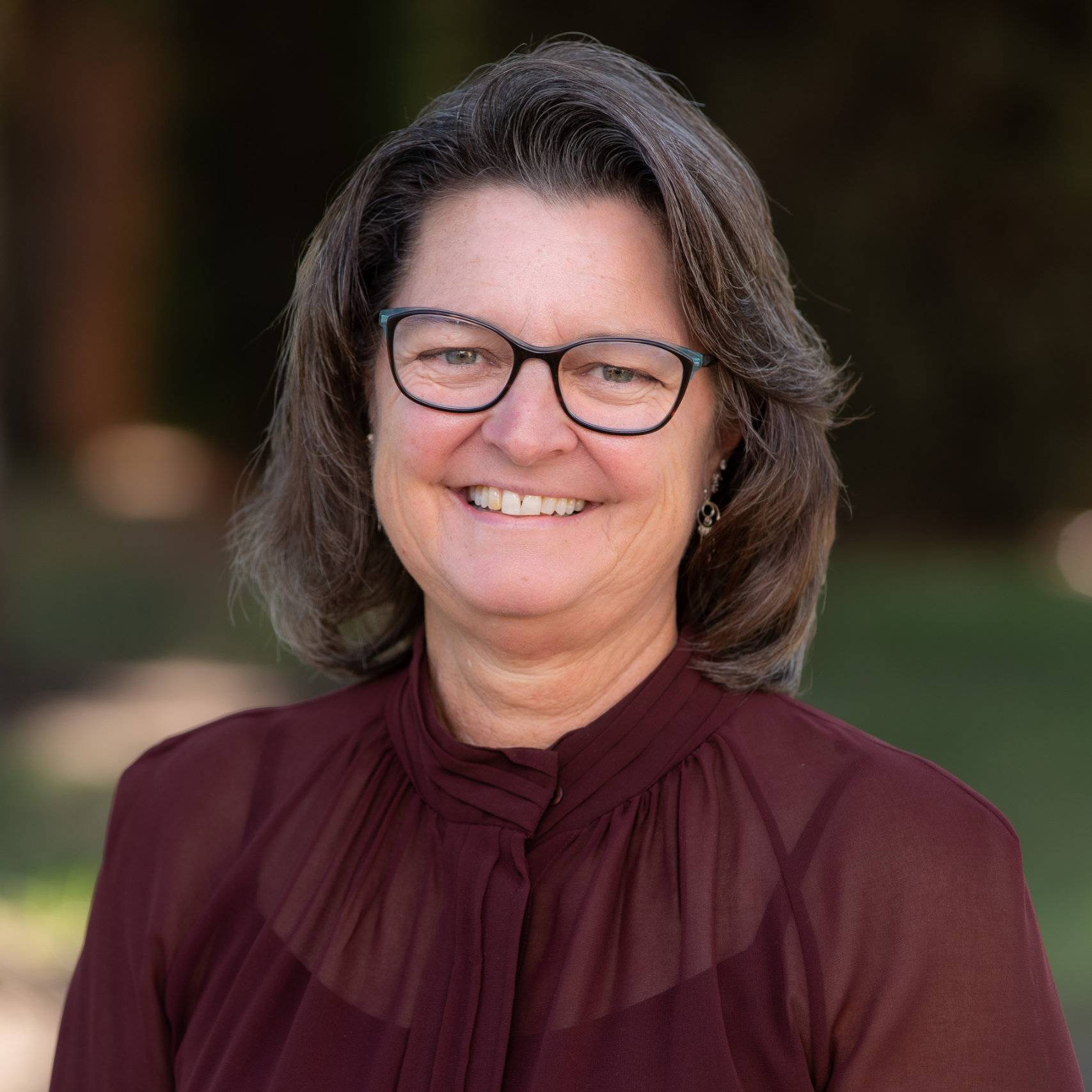 a woman wearing glasses smiling