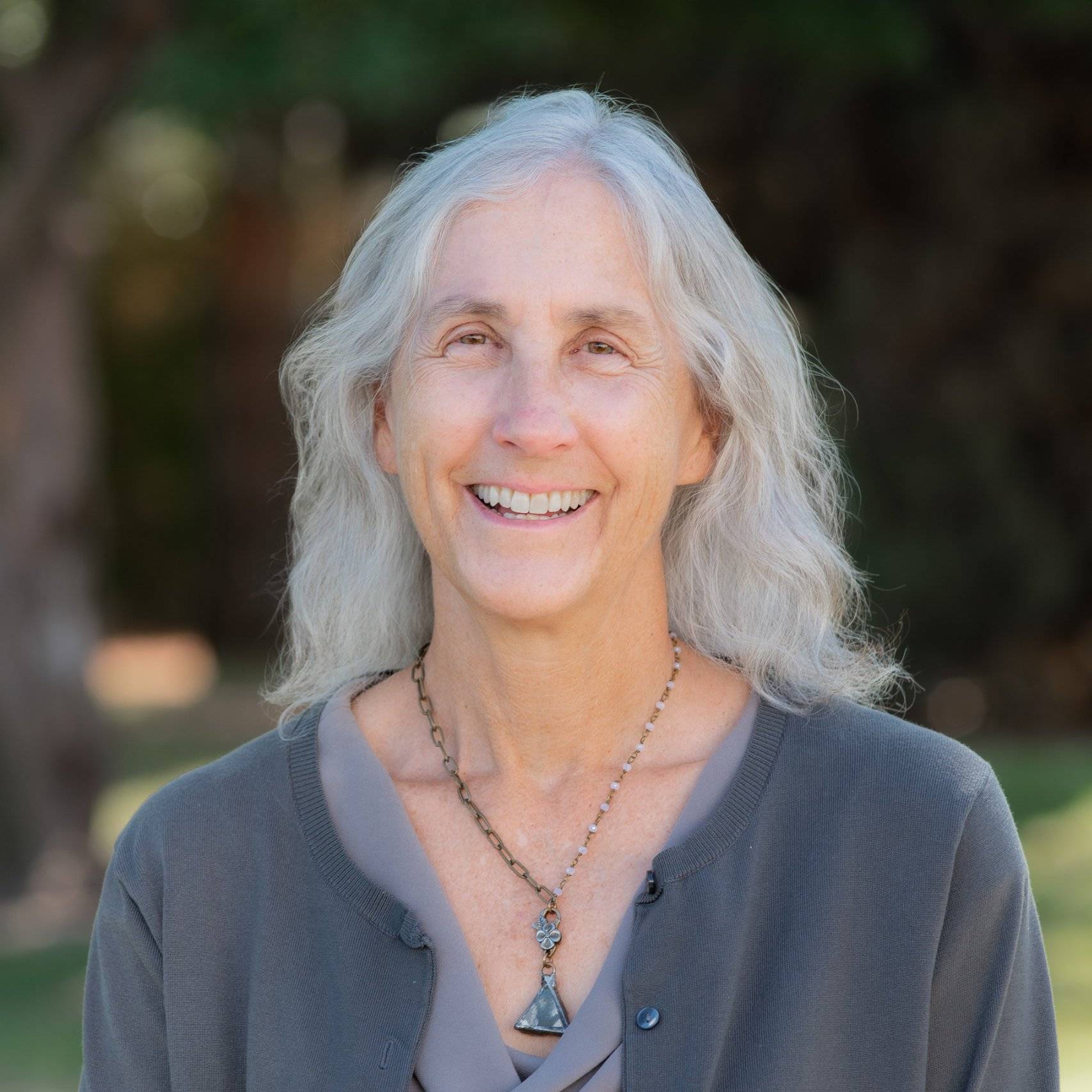 a woman with long gray hair smiling