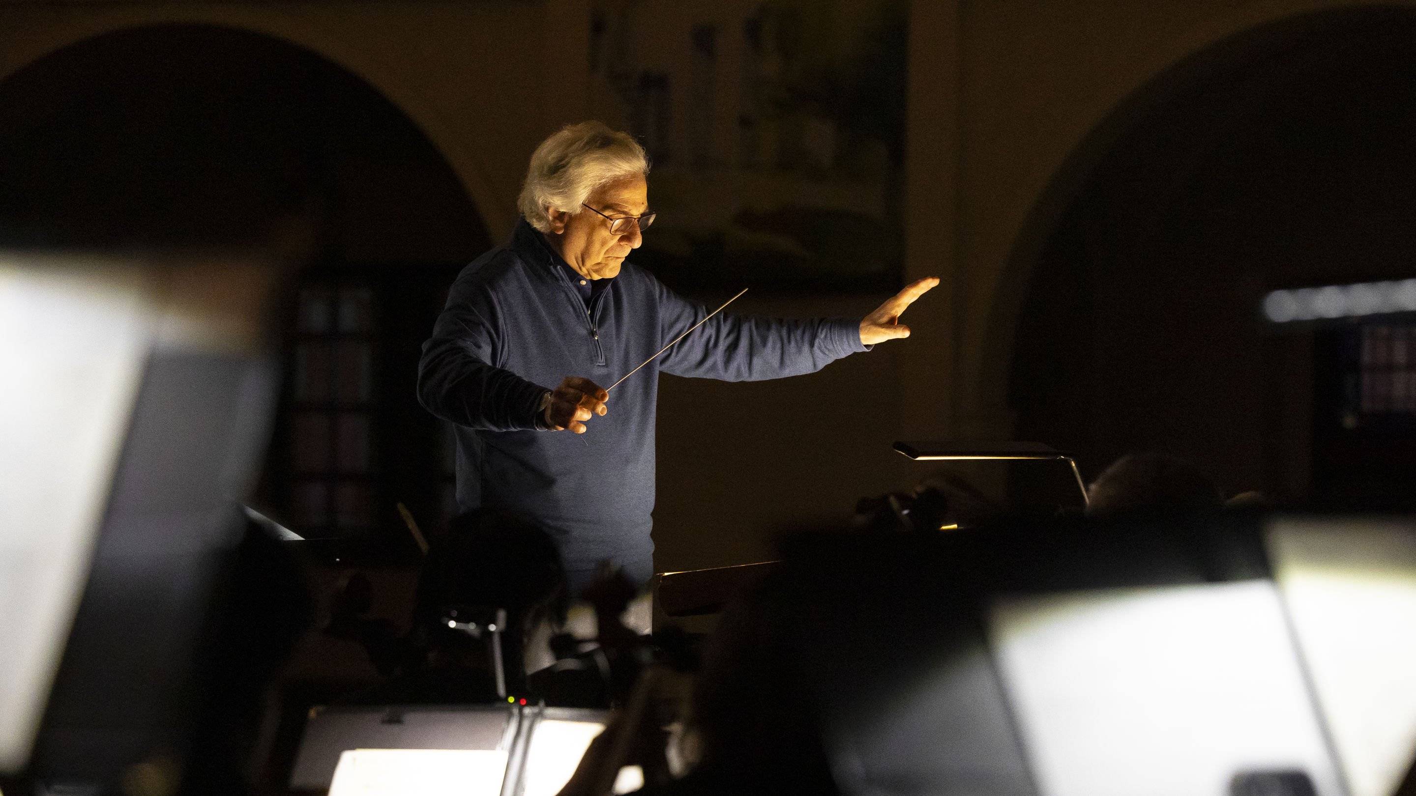 a man holding a stick in front of a piano