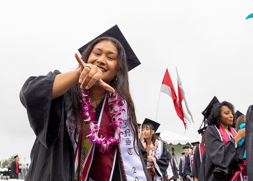 Smiling undergraduate student doing the shaka sign.