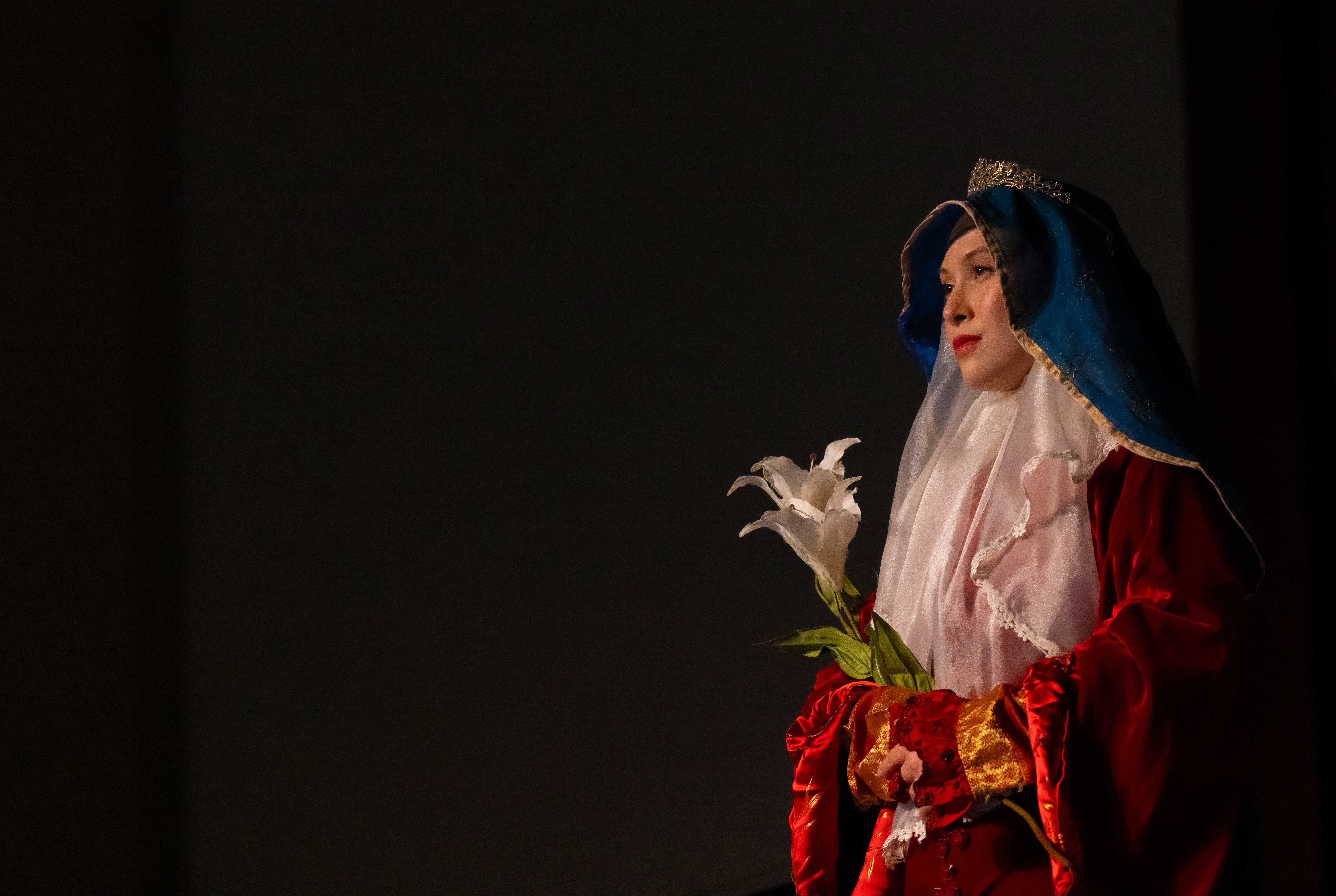 a woman in a red robe holding flowers