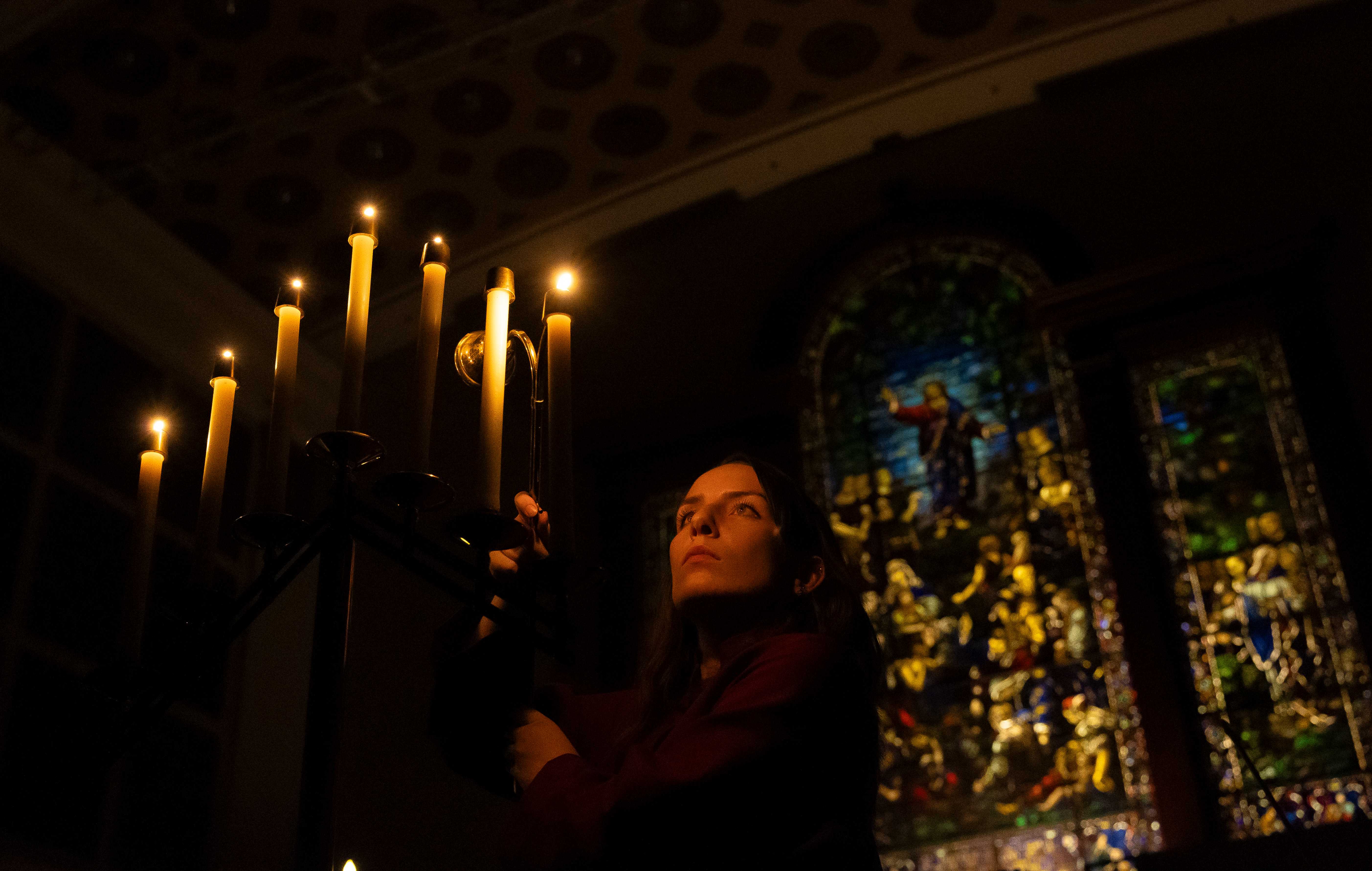 a woman holding candles in a dark room