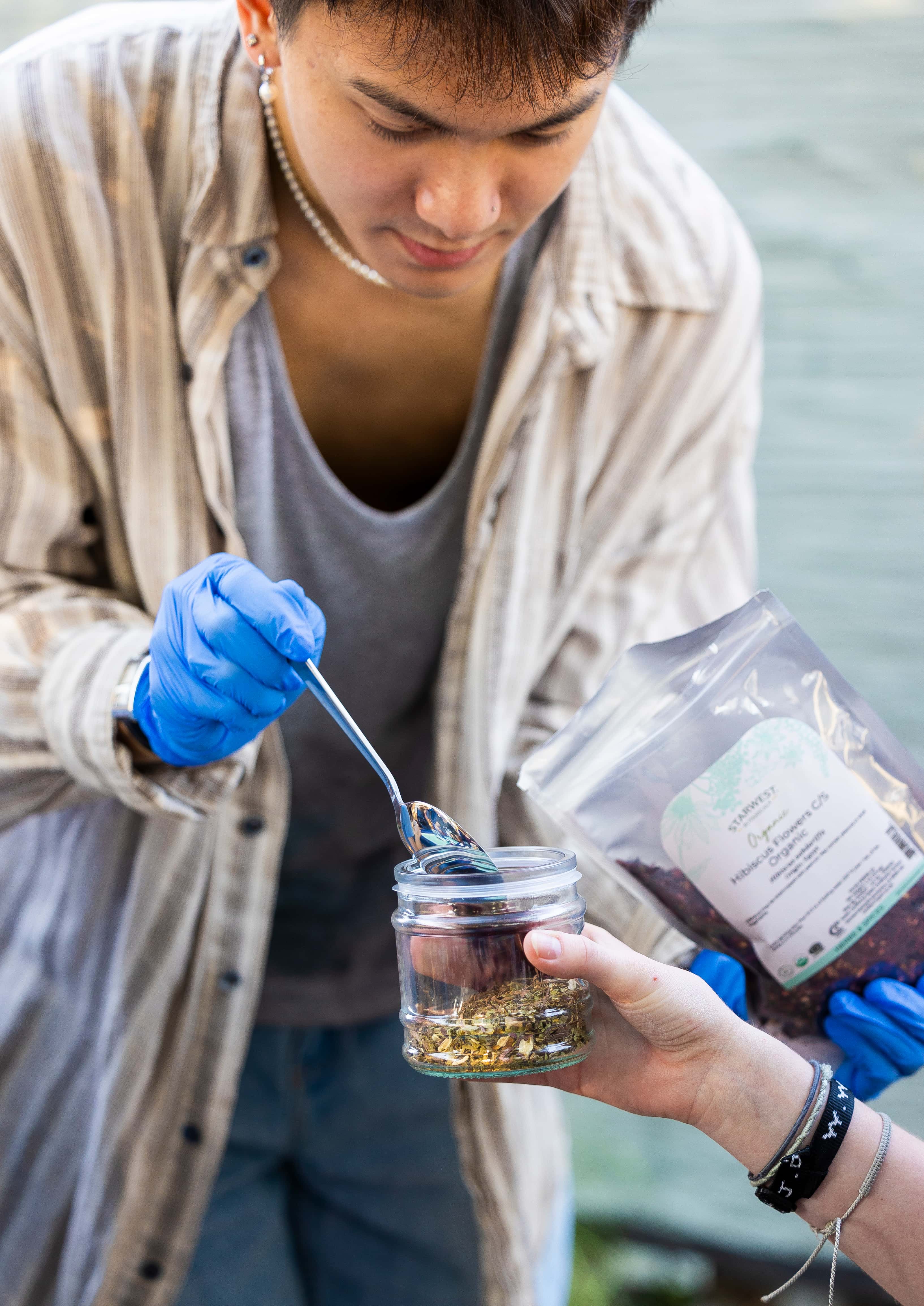a person holding a jar of liquid
