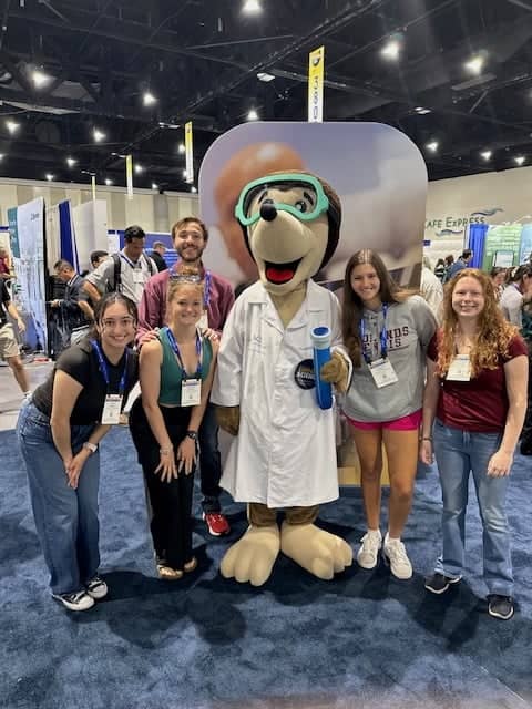 a group of people posing for a photo with a mascot