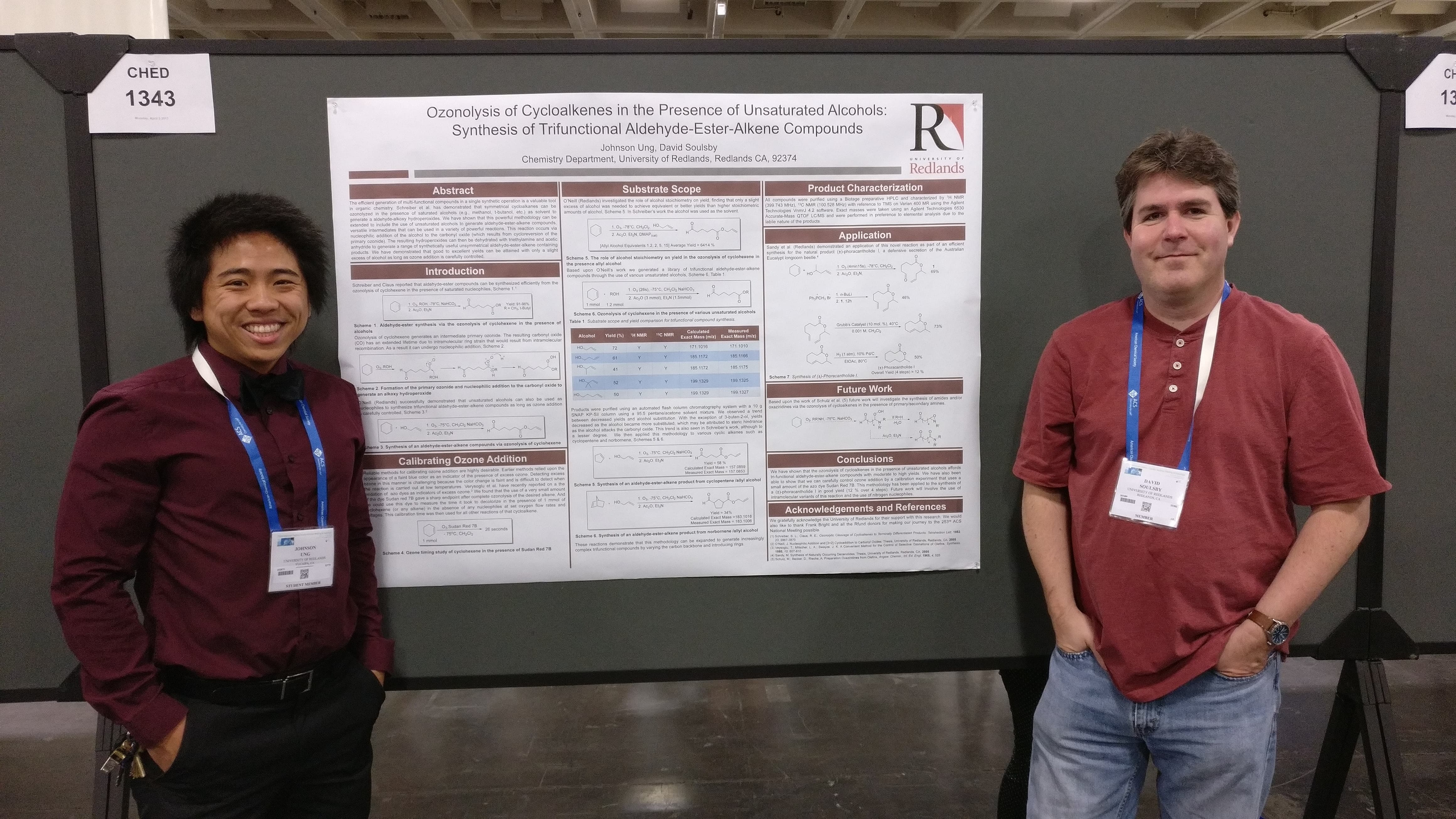 two men standing next to a poster