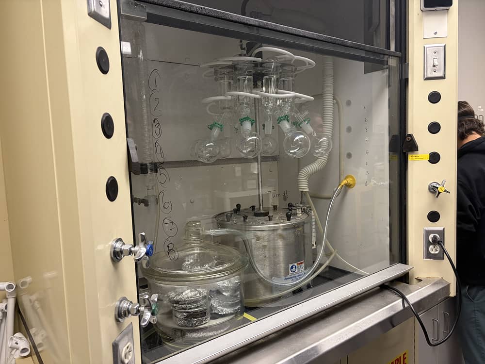 a glass container with round glass containers and a pipe in a cabinet