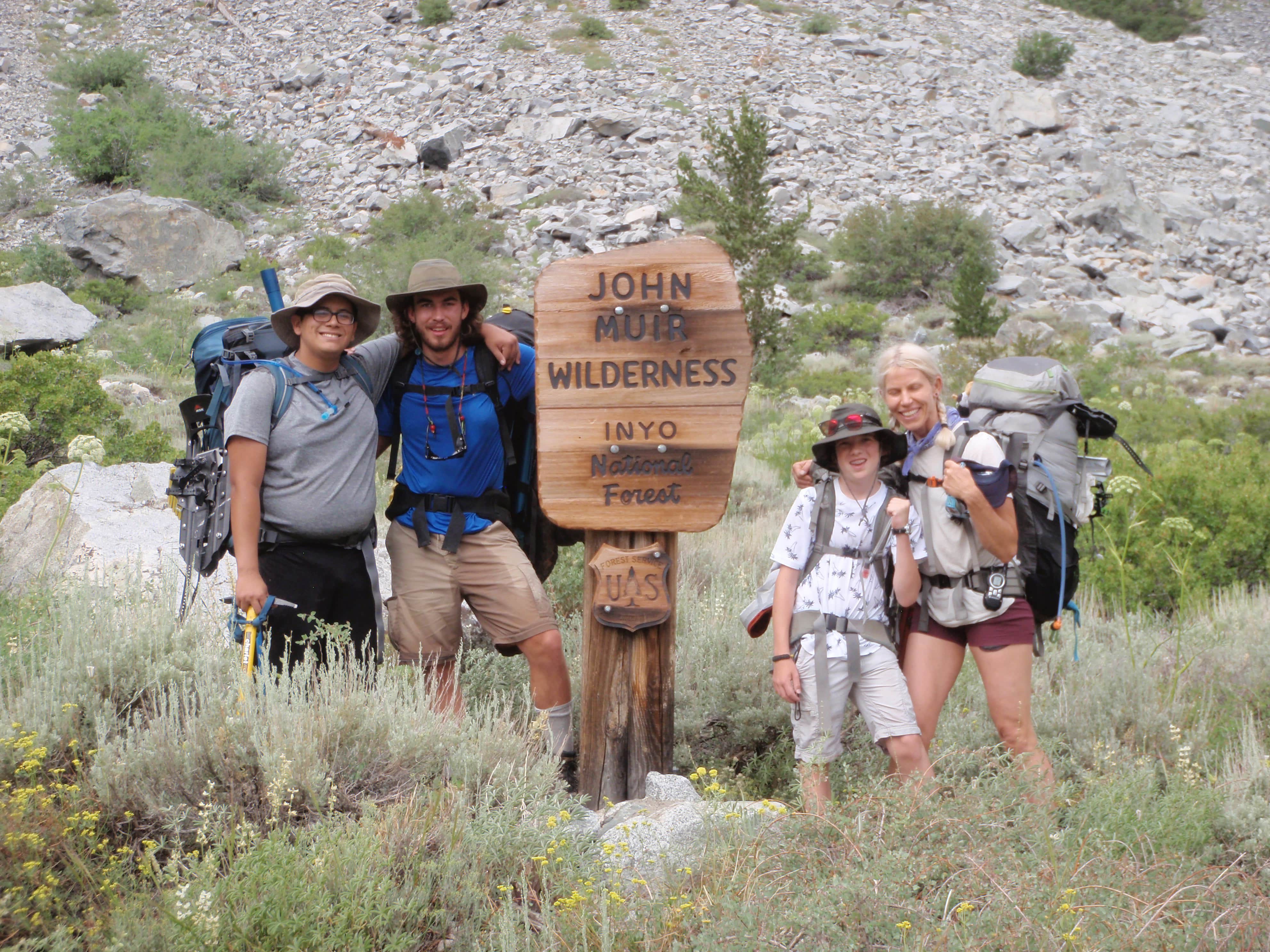 a group of people posing for a photo in front of a sign