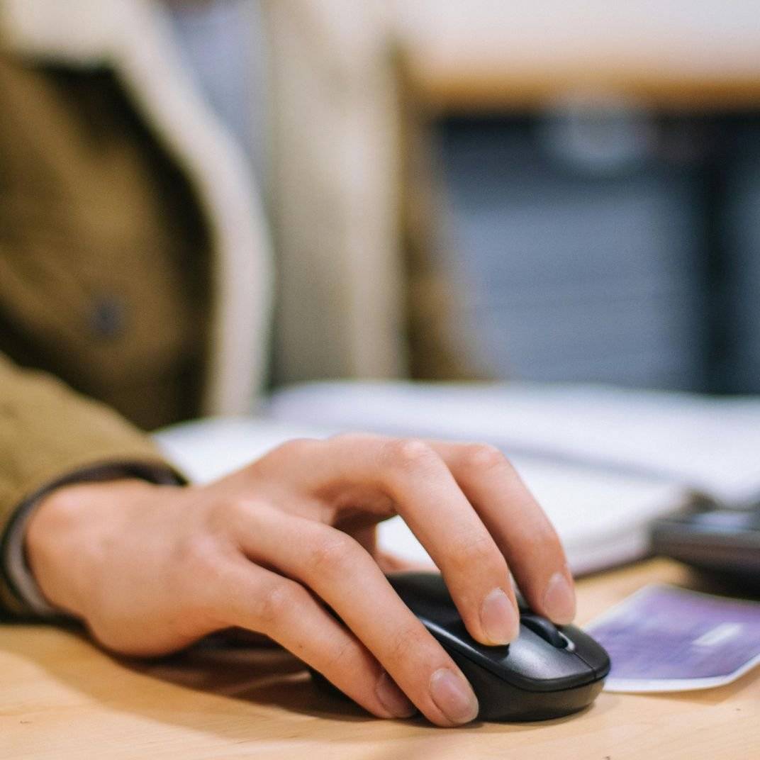 a hand holding a computer mouse