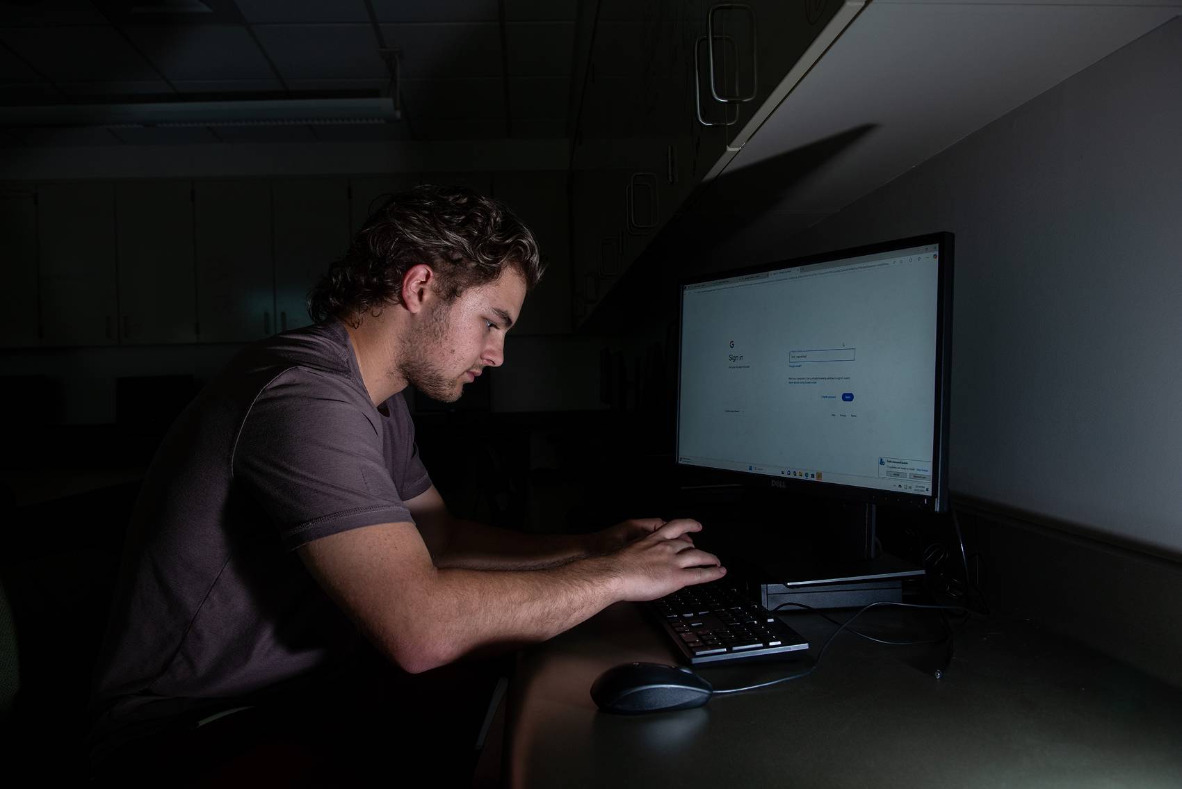 a man sitting at a desk working on a computer
