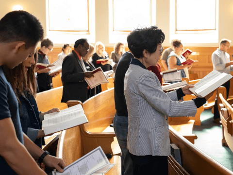 a group of people reading books in a church