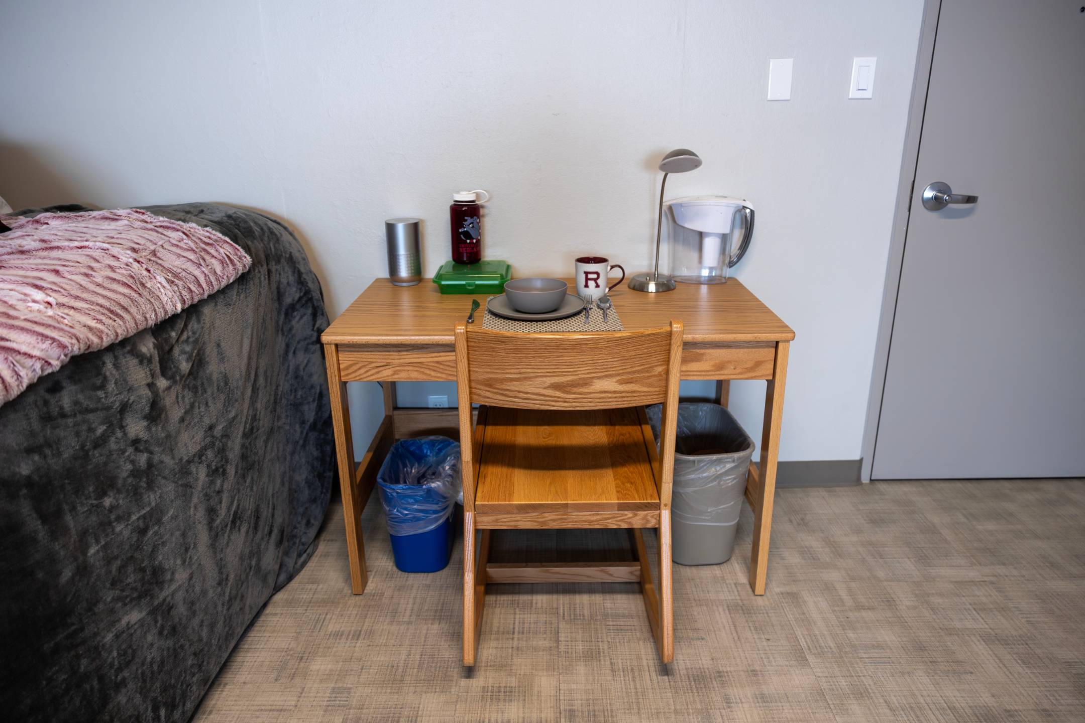 a table with a chair and a table with a lamp and a cup on it