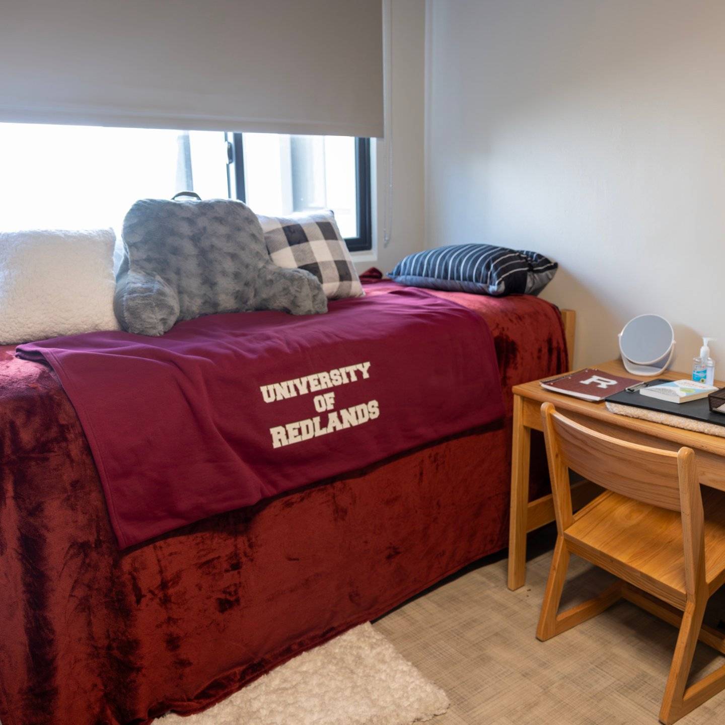 a bed with pillows and a desk in a room