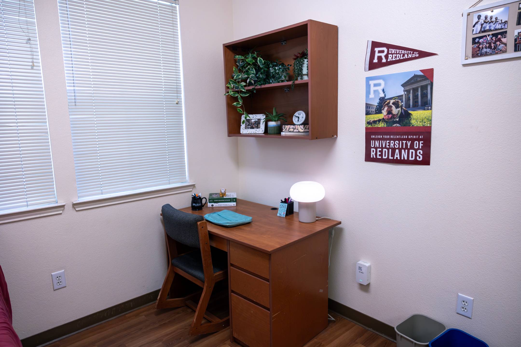a desk with a lamp and shelves on the wall