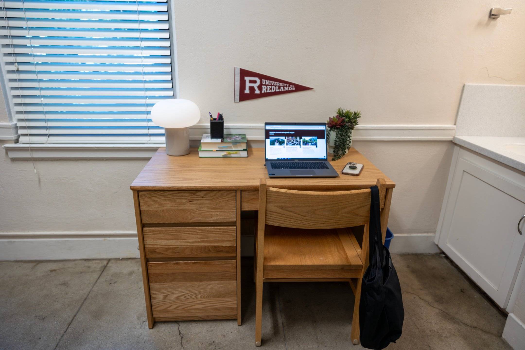 a desk with a laptop and a lamp
