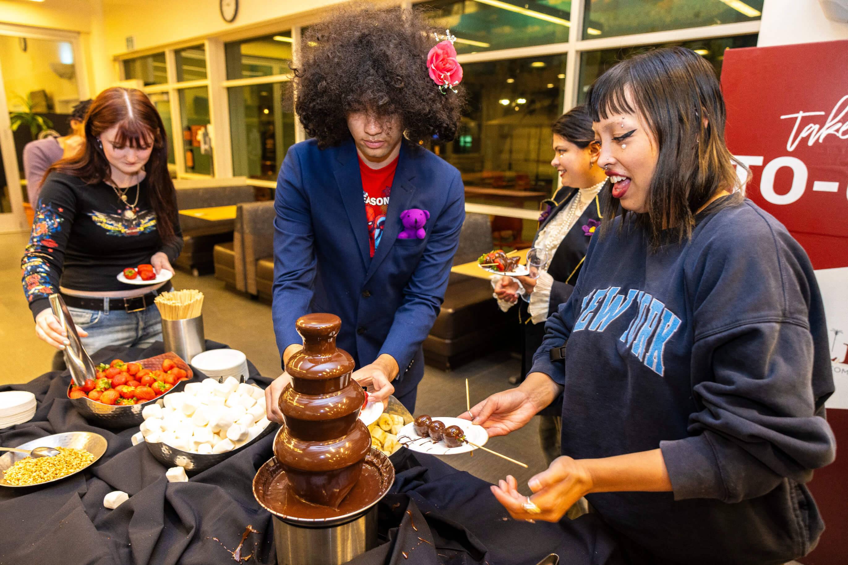 a group of people around a chocolate fountain