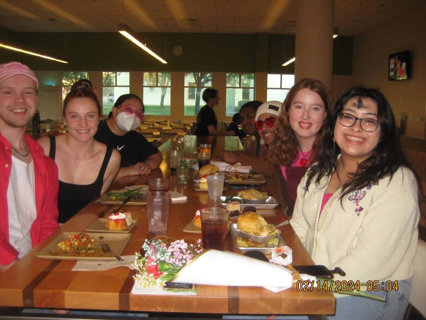 a group of people sitting at a table with food
