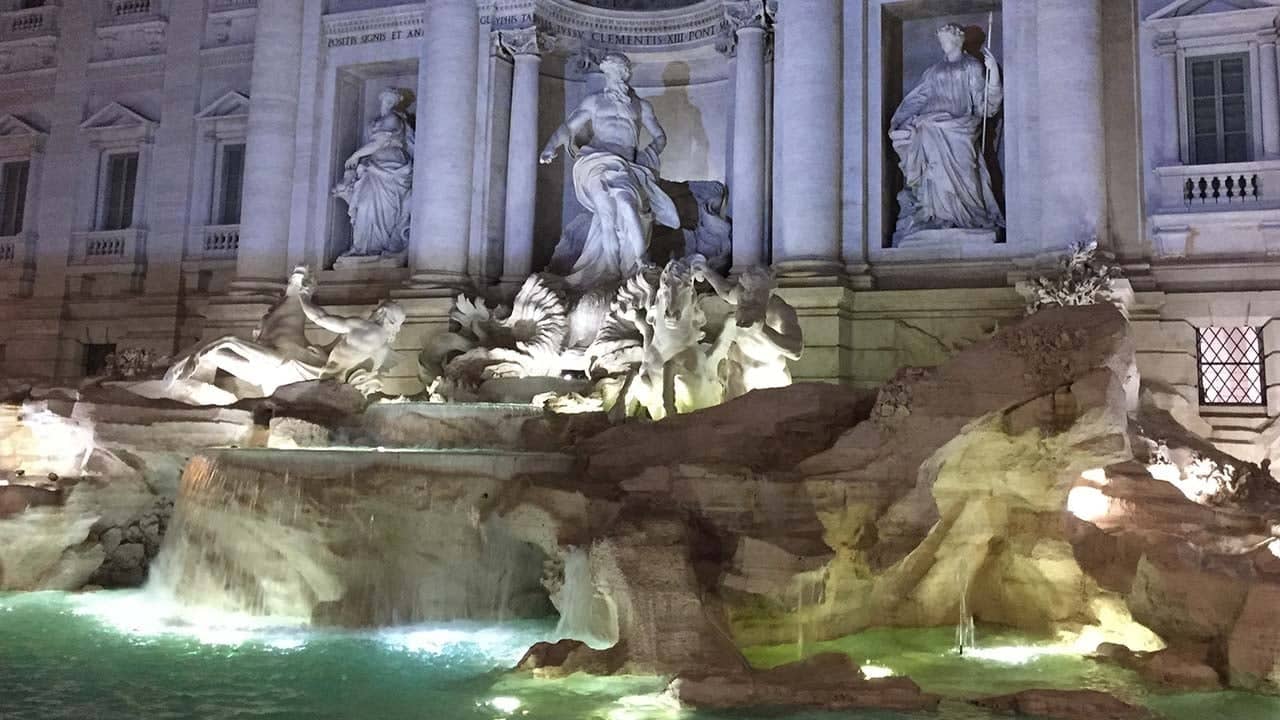 a large fountain with statues and columns with Trevi Fountain in the background
