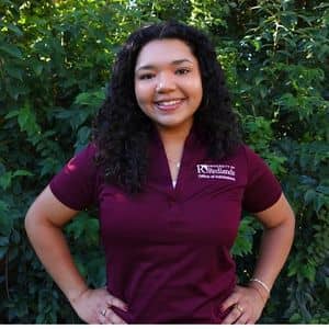 a woman smiling with her hands on her hips