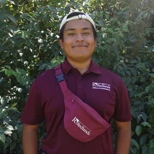 a man wearing a red shirt and white cap