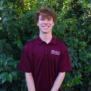 a man standing in front of a bush