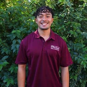 a man standing in front of bushes