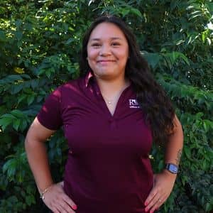 a woman standing in front of a bush