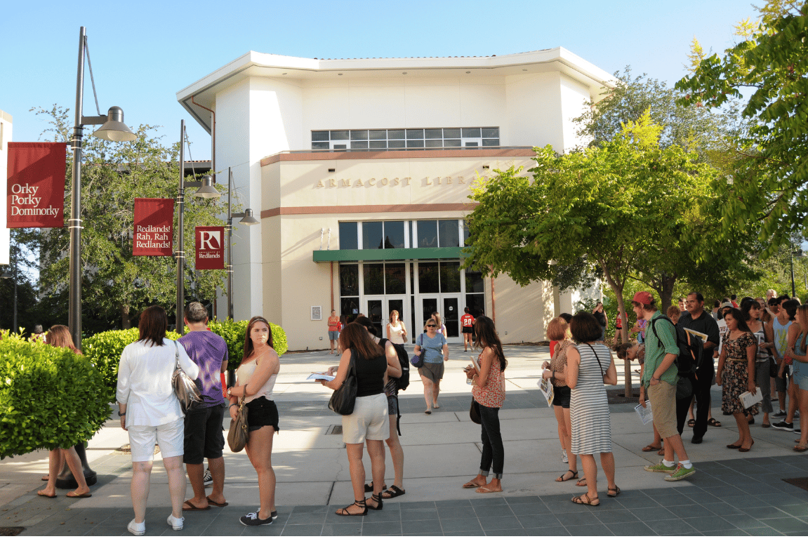 a group of people standing outside of a library