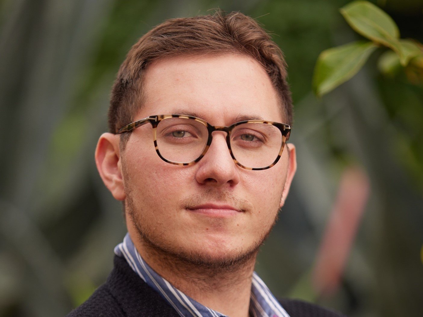 a man wearing glasses and a black jacket