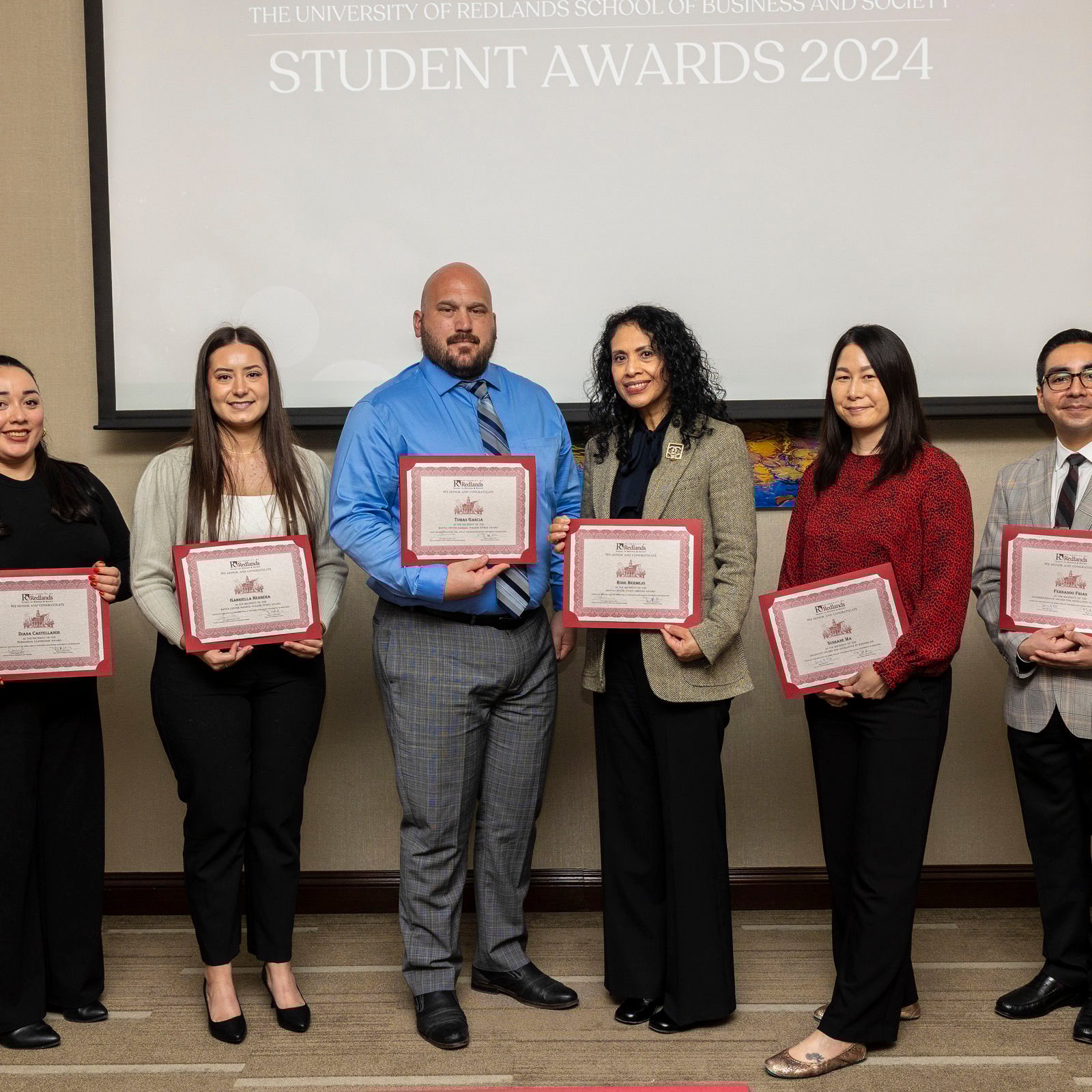 a group of people holding certificates