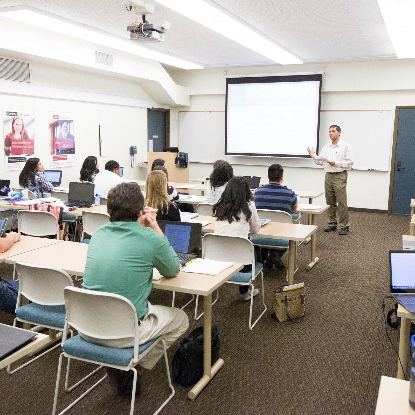 a man standing in front of a classroom with a group of people